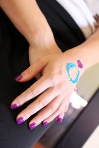 Pretty glitter tattoo matches purple manicure